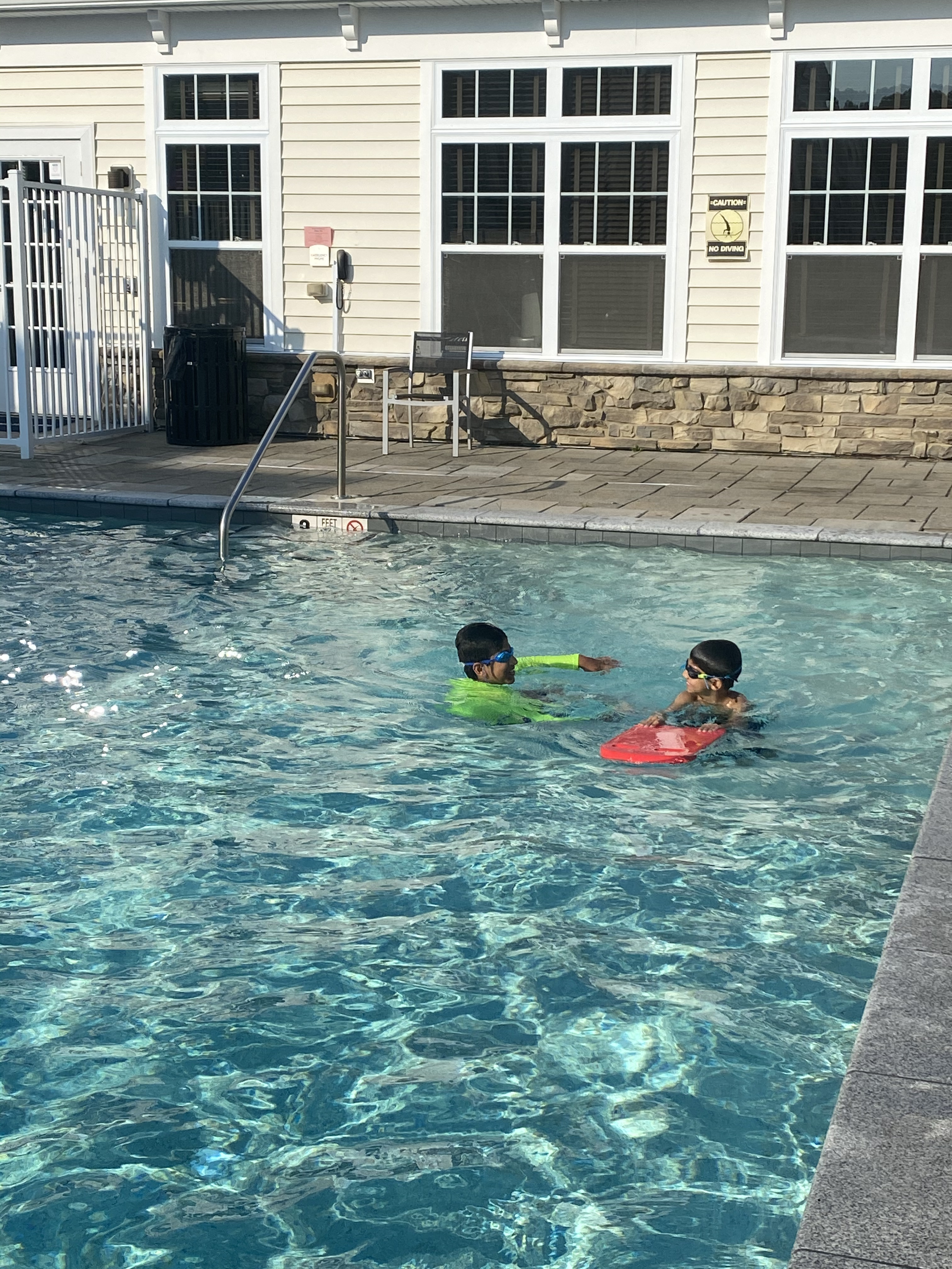Children learning to swim with instructor